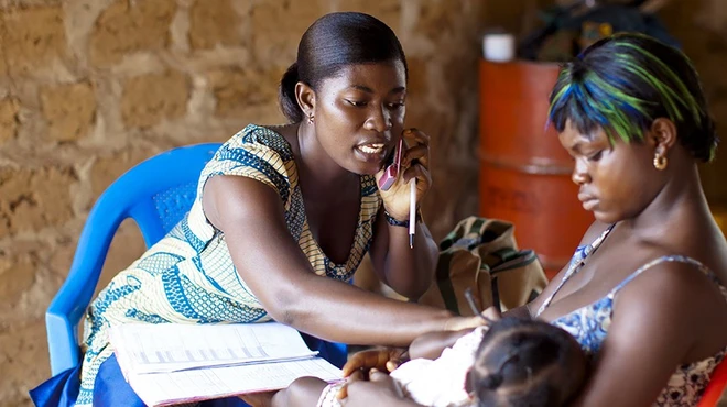 Medical worker talking on phone treating patients in Africa
