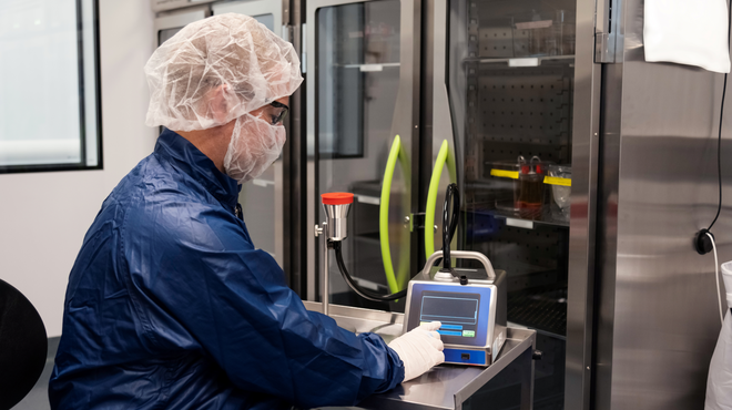 Associate in full personal protective equipment conducting quality control testing
